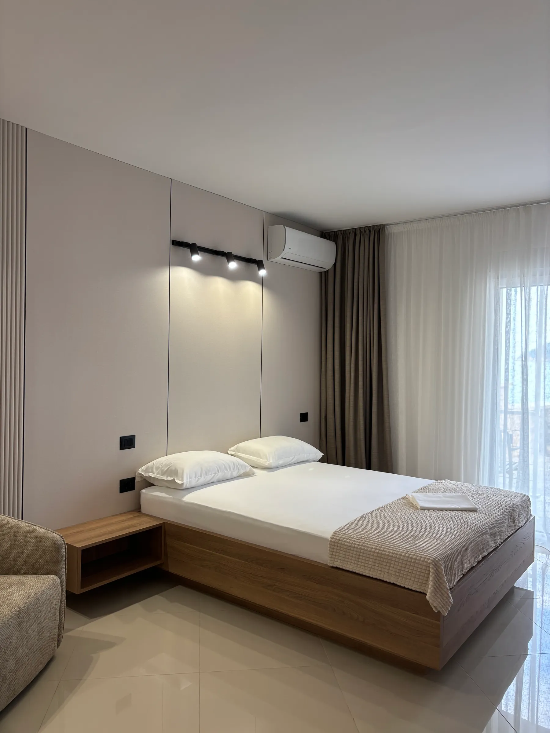 Spavaća soba apartmana sa lamelnim zidnim panelom pored kreveta